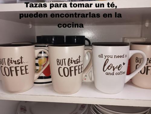 a group of coffee mugs sitting on a shelf at Hostal Pampaloja Antof in Antofagasta