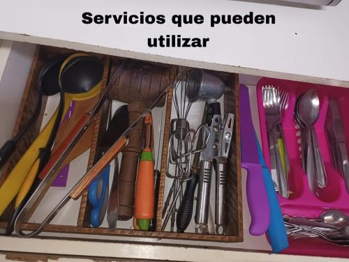 a drawer filled with utensils on a shelf at Hostal Pampaloja Antof in Antofagasta