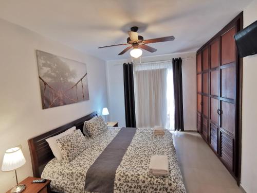 a bedroom with a bed and a ceiling fan at LAS PALMAS - DELUXE VILLAS and SUITES - playa LOS CORALES in Punta Cana