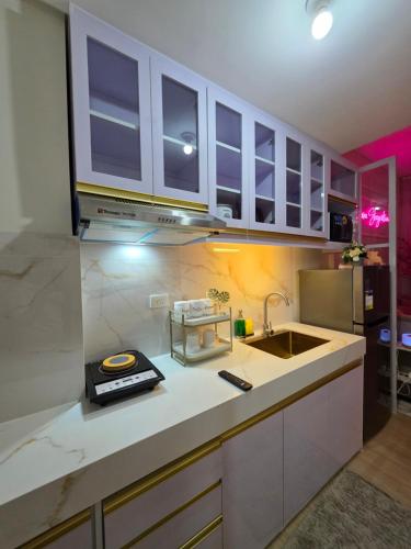 a kitchen with white cabinets and a sink at Affordable New Staycation Condo in Quezon City in Manila