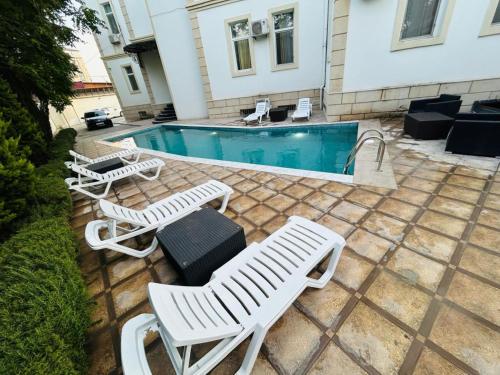 a group of white chairs and a swimming pool at Family Hotel - Free Massage in Baku