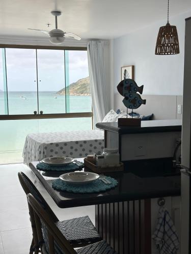 a kitchen with a table with a view of the ocean at Arraial do cabo loft prainha in Arraial do Cabo
