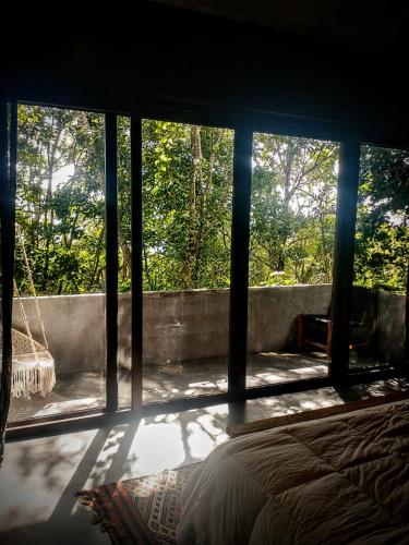 a bedroom with a large window with a bed in it at Casa Vive Bacalar in Bacalar