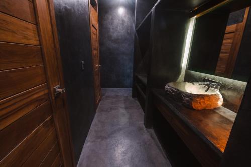 a bathroom with a stone sink and a mirror at Casa Vive Bacalar in Bacalar
