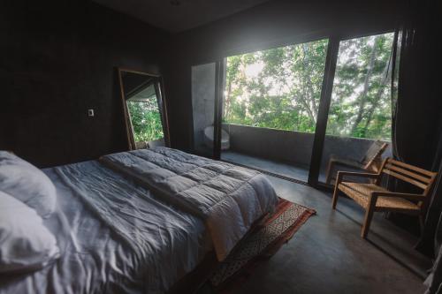 a bedroom with a bed and a large window at Casa Vive Bacalar in Bacalar