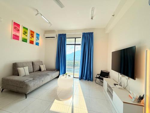 a living room with a couch and a flat screen tv at The Sun Executive Suite - Dolphin's Home in Bayan Lepas