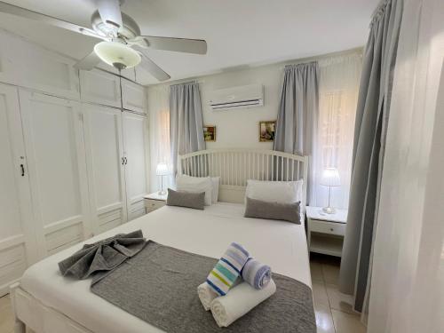a white bedroom with two beds and a crib at LAS PALMAS - DELUXE VILLAS and SUITES - playa LOS CORALES in Punta Cana