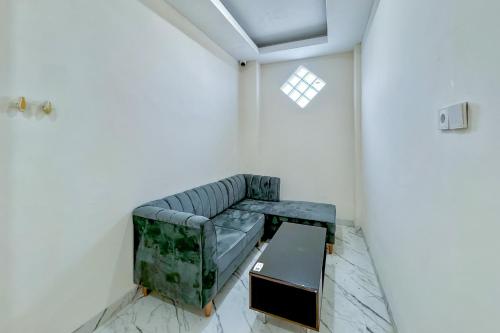 a living room with a couch and a table at Urbanview Olive Near Graha Saba Buana Surakarta in Bonorejo