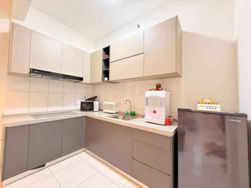 a kitchen with white cabinets and a refrigerator at The Sun Executive Suite - Dolphin's Home in Bayan Lepas