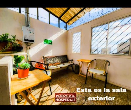 a room with a table and a couch in a room at Hostal Pampaloja Antof in Antofagasta