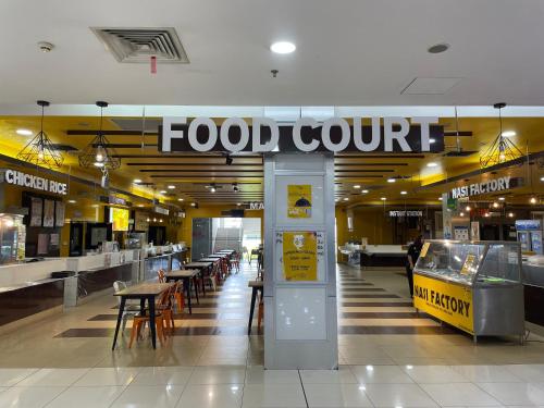 a food court with tables and chairs in a mall at Times Hotel Brunei in Bandar Seri Begawan