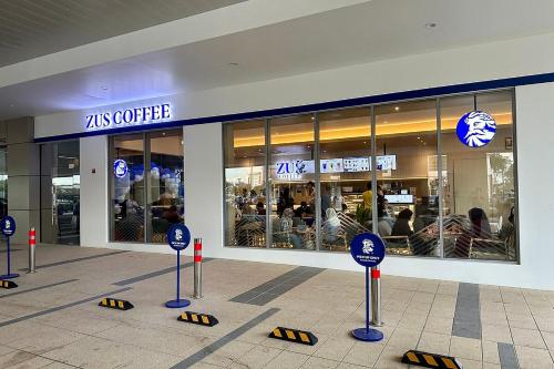 a restaurant with blue signs in front of a store at Times Hotel Brunei in Bandar Seri Begawan