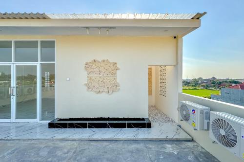 a white house with a balcony with a fan at Urbanview Olive Near Graha Saba Buana Surakarta in Bonorejo