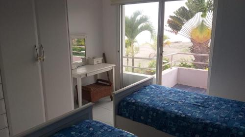 une chambre avec un lit, un miroir et une fenêtre dans l'établissement Departamento para 6 personas Atacames, à Atacames