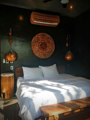 a bedroom with a white bed and some lights at Casa Vive Bacalar in Bacalar