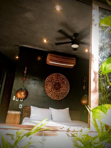 a bedroom with a bed and a ceiling fan at Casa Vive Bacalar in Bacalar