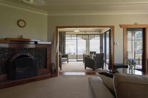 a living room with a fireplace and a couch at Bay View Terrace Studio 3 in Tataraimaka