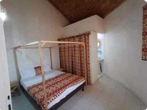 a bedroom with a canopy bed in a room at Djembé B&B in Mbour