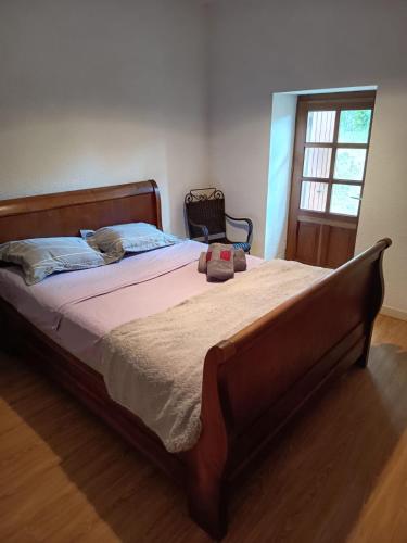 a bedroom with a large bed with a wooden frame at Maison de vacances en Ardèche in Pailharès