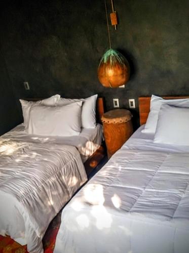 two beds sitting next to each other in a bedroom at Casa Vive Bacalar in Bacalar