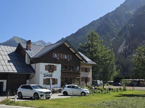 two cars parked in a parking lot in front of a building at Holiday Apartment in Mittelberg with Wifi in Mittelberg