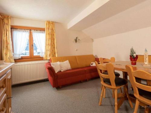 a living room with a red couch and a table at Holiday Apartment in Mittelberg with Wifi in Mittelberg