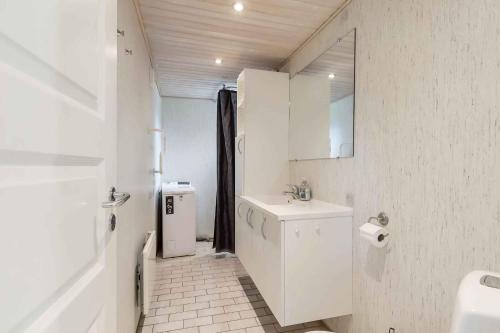 a white bathroom with a sink and a toilet at Well-Located Holiday Home In Ristinge, Langeland in Humble