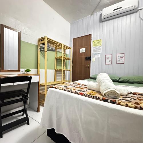 a room with a bed with a desk and a desk at Residencial Napolitan in Manaus