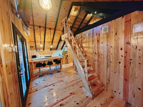 a room with wooden walls and a wooden staircase at Black Birds Cabins Creel in Creel