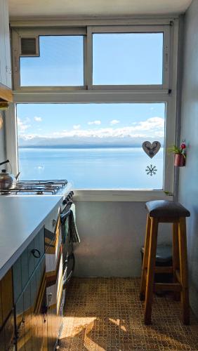 a kitchen with a window with a view of the ocean at Giraluna Center depto con vista al lago en Bariloche in San Carlos de Bariloche