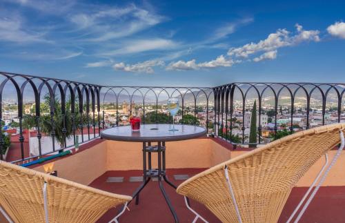 a balcony with a table and two chairs at Casa Mayahuel in Oaxaca City