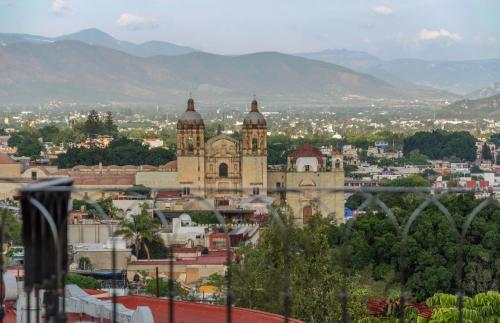 a view of a city with a church and mountains at Casa Mayahuel in Oaxaca City