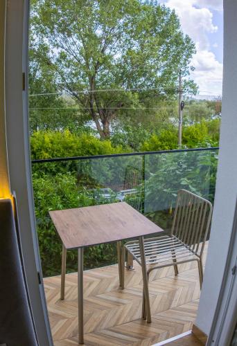 a wooden table and a chair on a balcony at Villa Osmani in Shkodër