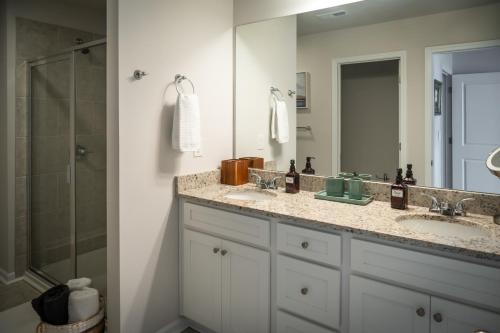 a bathroom with two sinks and a shower at Shoo Fly at Lake Oconee - Lakefront, Kayaks, Games in Eatonton
