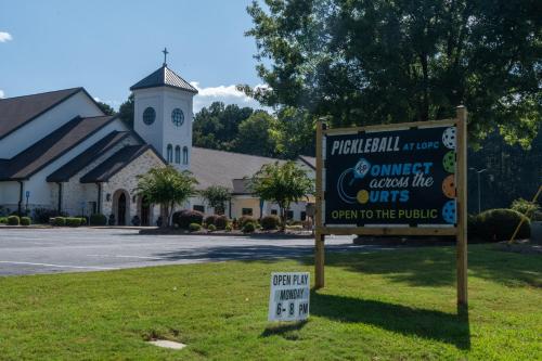 a sign in the grass in front of a church at Shoo Fly at Lake Oconee - Lakefront, Kayaks, Games in Eatonton