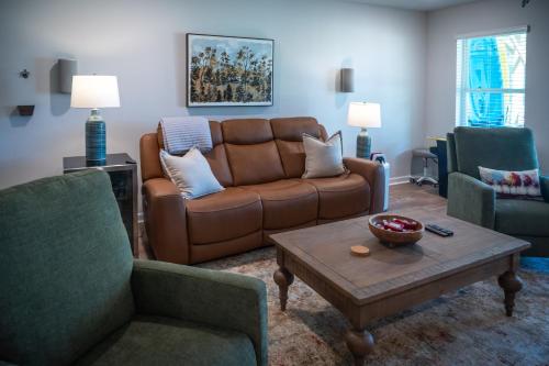 a living room with a brown couch and two chairs at Shoo Fly at Lake Oconee - Lakefront, Kayaks, Games in Eatonton