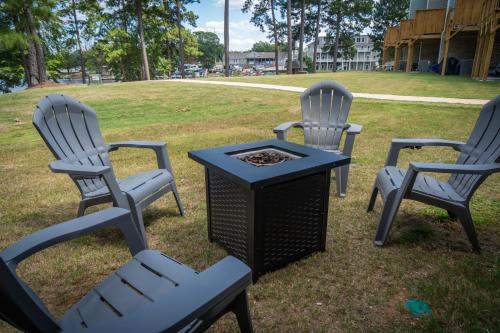 three chairs and a table with a grill in the grass at Shoo Fly at Lake Oconee - Lakefront, Kayaks, Games in Eatonton
