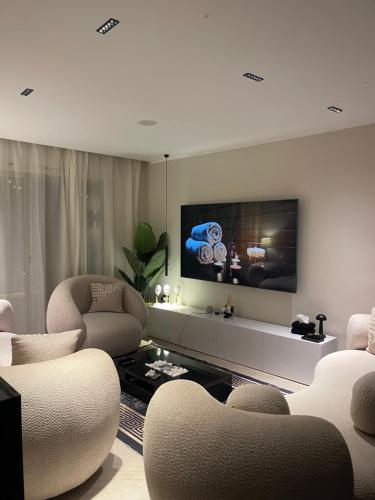a living room with chairs and a flat screen tv at اكوا فيو الساحل الشمالي in El Alamein