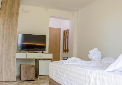 a bedroom with a bed and a flat screen tv at Villa Osmani in Shkodër