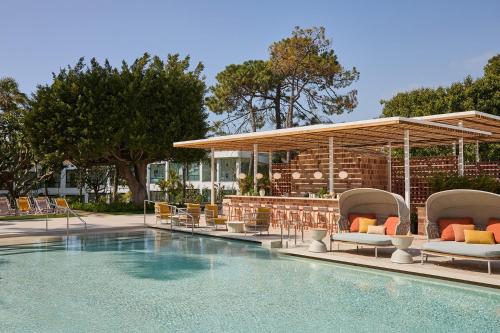a swimming pool with lounge chairs and a bar at Kimpton Los Monteros Marbella by IHG in Marbella