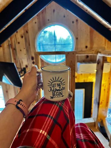 a person is holding a coffee cup on their head at Black Birds Cabins Creel in Creel