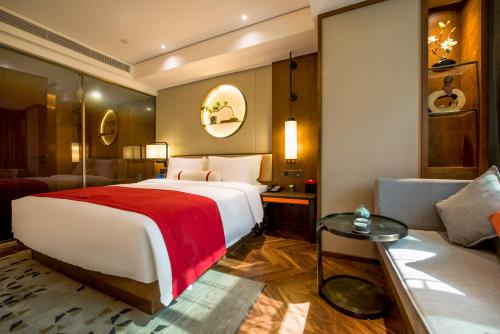 a hotel room with a large bed and a couch at Ease Hotel · Yi (Xi’an Bell and Drum Tower Xiaozhai Datang Everbright City) in Xi'an