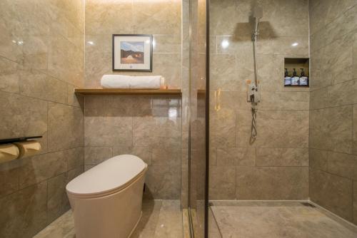 a bathroom with a toilet and a shower at Ease Hotel · Yi (Xi’an Bell and Drum Tower Xiaozhai Datang Everbright City) in Xi'an