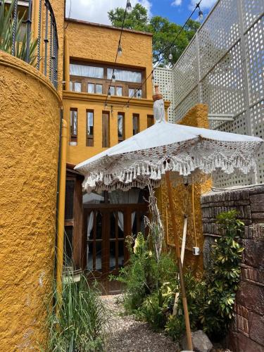 an umbrella in a garden in front of a building at Hotel Casa Rosario in San Miguel de Allende