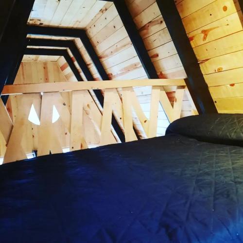 a bed in a room with a wooden ceiling at Black Birds Cabins Creel in Creel