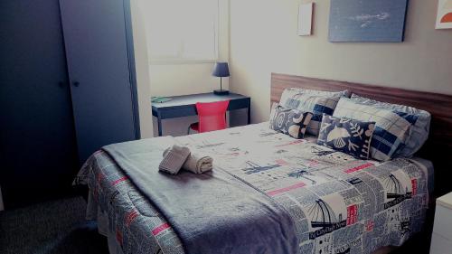 a bedroom with a bed with two books on it at Apartamento Cambui - Centro de Convivência in Campinas