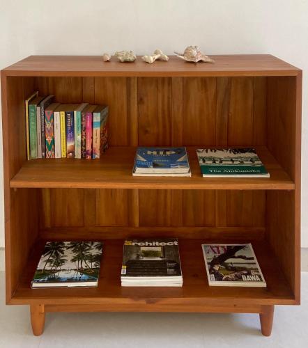 a wooden book shelf with books and books at Beachside Stay Steps From Mawella Bay, Tangalle #thisisnotahotel in Mawella