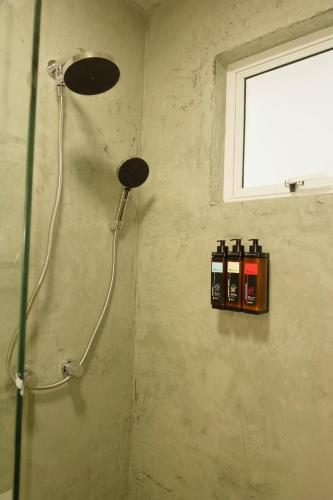 Un cabezal de ducha en un baño con ventana. en Espaço Áurea, en Campina Grande do Sul