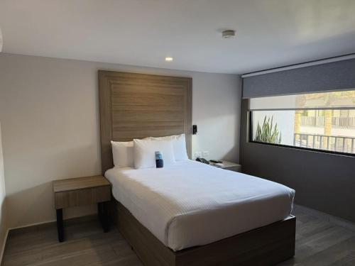 a bedroom with a large white bed and a window at Comfort Inn Hermosillo Pitic in Hermosillo