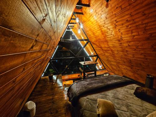 a room with a large bed in a wooden ceiling at Glamping Hakuna Matata in Monguí